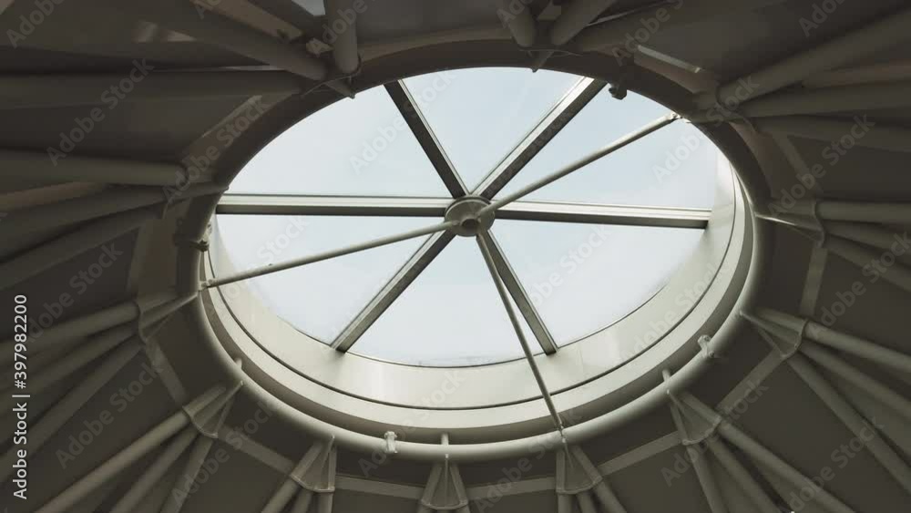 Top view on Structural glass facade curving roof of office building. Modern and contemporary architectural fiction with glass steel column. Aerial shot of glass dome construction Top view on Structural glass facade curving roof of office building. Modern and contemporary architectural fiction with glass steel column. Aerial shot of glass dome construction