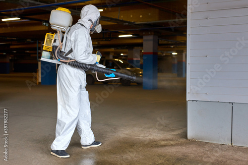 worker in hazmat suit is making disinfection outdoors, coronavirus decontamination for people healthcare