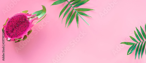Fresh organic pink dragon fruit, pitaya or pitahaya with pink middle. Trendy banner, flat lay. Panoramic image on pink background with copy-space.. photo