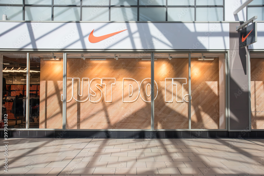 Exterior of Nike sports clothing store shop showing company logo, sign,  signage and branding. High street shopping. Just Do It Stock Photo | Adobe  Stock
