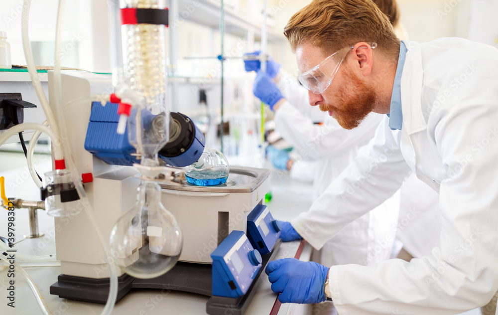 Research scientist looking at reaction in test tube in laboratory Research scientist looking at reaction in test tube in laboratory