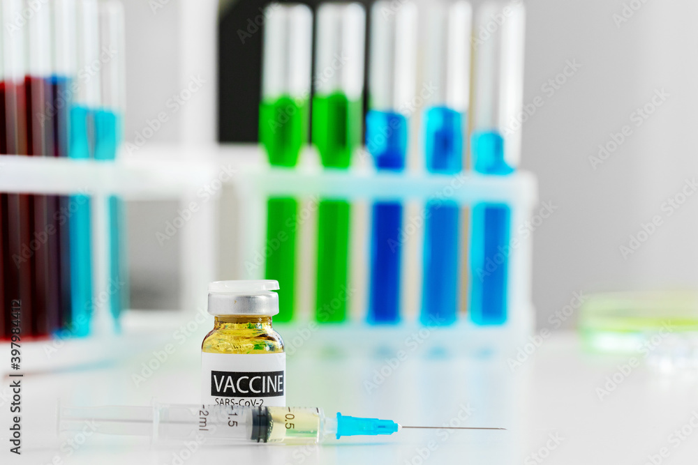 Vaccine in vial for injection on table against background of laboratory Vaccine in vial for injection on table against background of laboratory