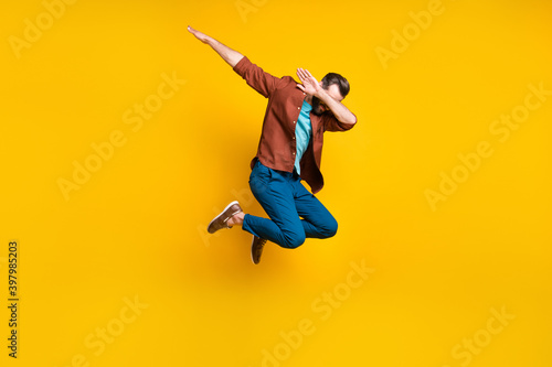 Full length body size photo of male student showing hype dab sign jumping isolated on vivid yellow color background