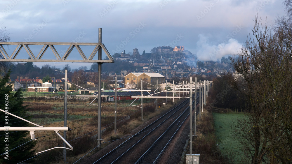 Railway tracks going towards a city of Stirling with Stirling Castle standing tall on a hill