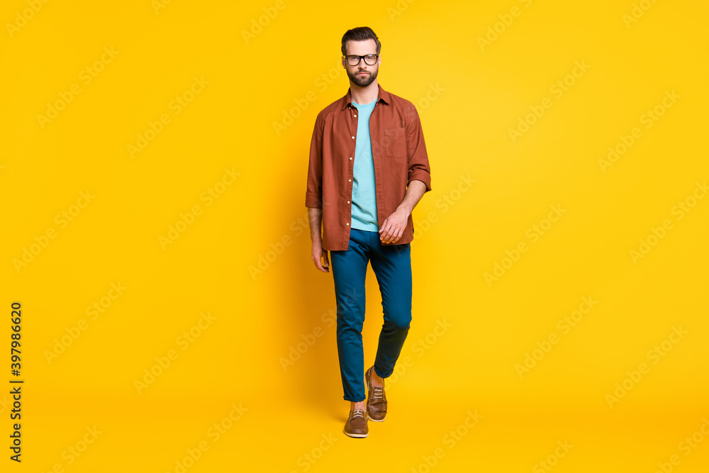 Full length body size photo of stylish millennial wearing casual clothes eyewear isolated on vivid yellow color background Full length body size photo of stylish millennial wearing casual clothes eyewear isolated on vivid yellow color background