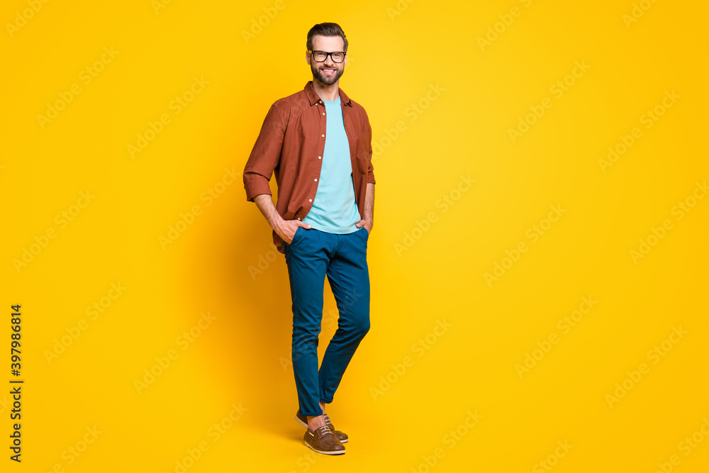 Full length body size photo of happy businessman in spectacles brown casual shirt isolated on bright yellow color background Full length body size photo of happy businessman in spectacles brown casual shirt isolated on bright yellow color background