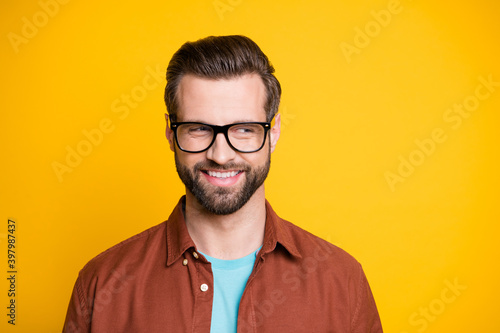 Photo of attractive charming dreamy young man look stand empty space good mood isolated on yellow color background