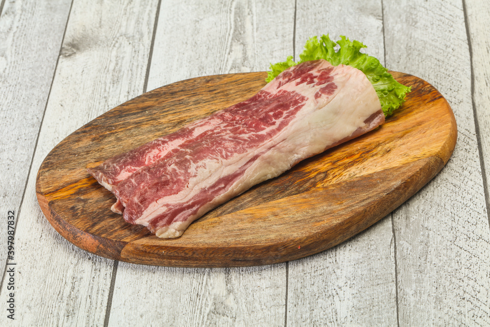 Raw beef bacon over wooden board Raw beef bacon over wooden board