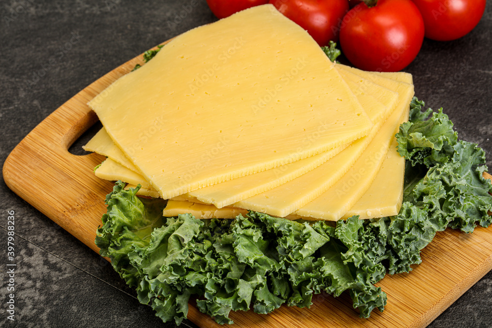 Sliced Gauda cheese over board Sliced Gauda cheese over board