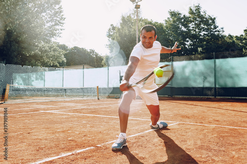 Fit man plays tennis on tennis field © fotofabrika