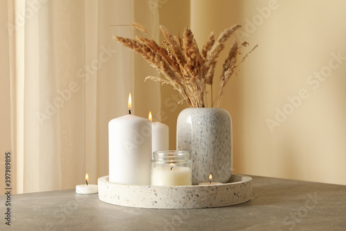Tray with scented candles and reed on gray table