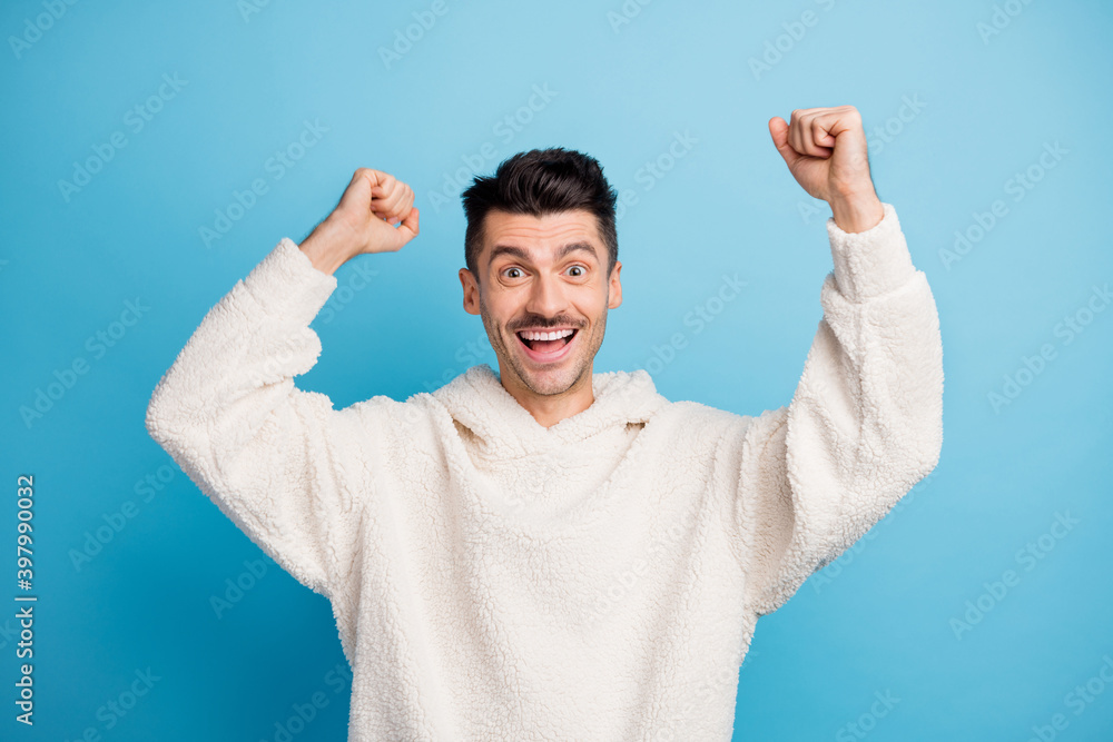 Photo portrait of man with bristle celebrating raising two fists isolated on pastel blue colored background Photo portrait of man with bristle celebrating raising two fists isolated on pastel blue colored background