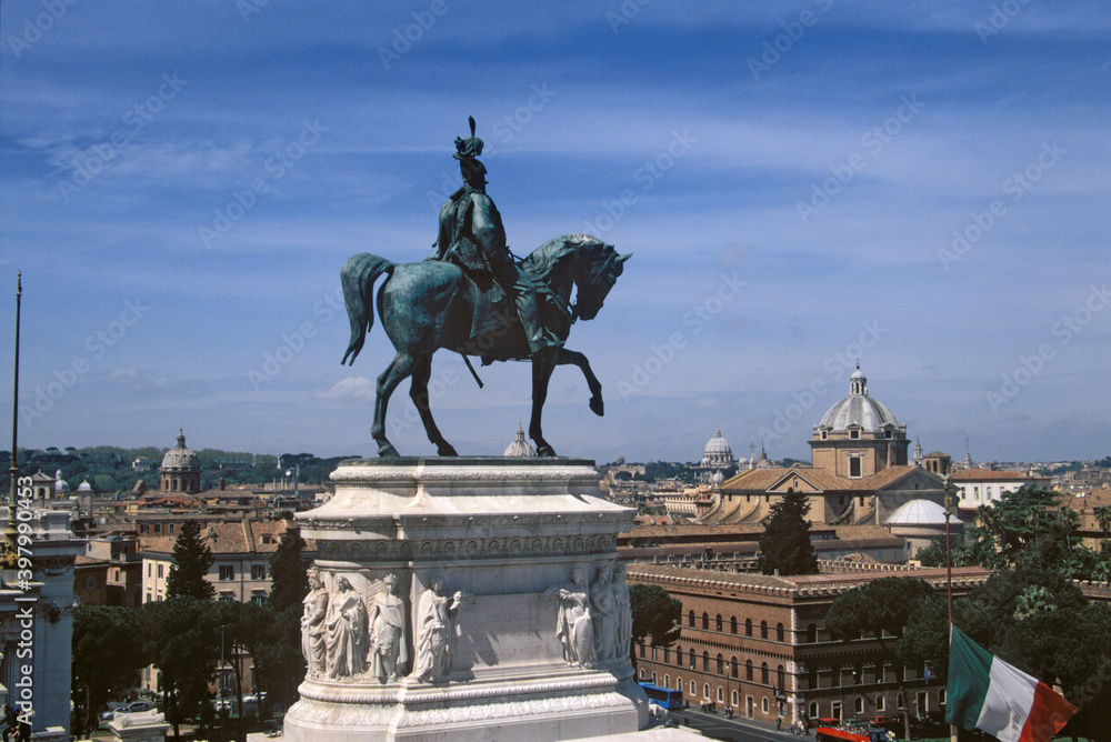 View of Victor Emmanuel II Monument with city skyline under blue sky at Piazza Venezia, Rome, Italy.
