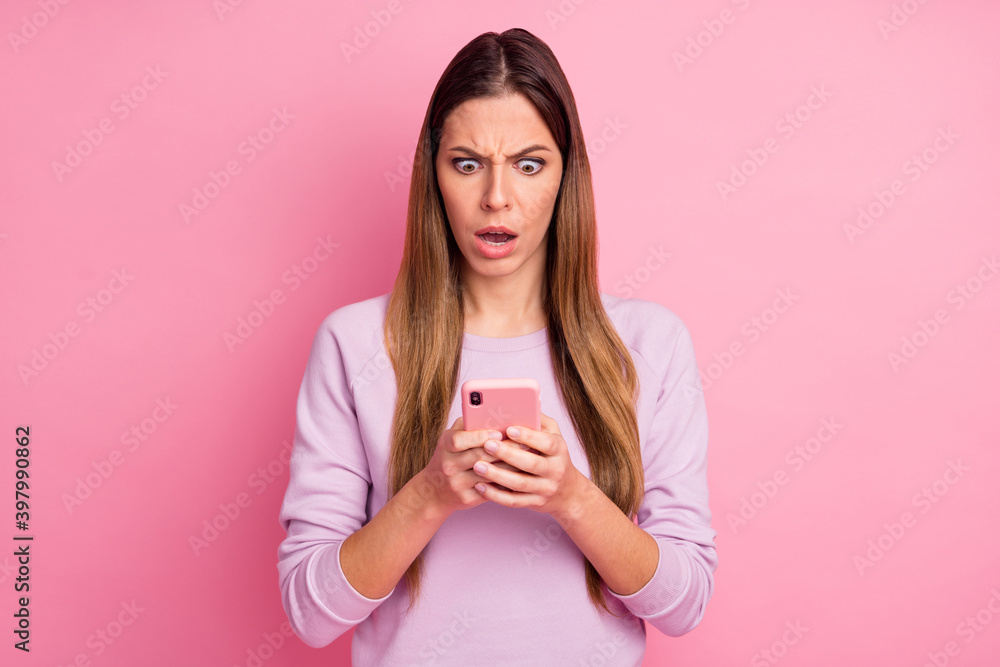 Close-up portrait of lovely outraged straight-haired girl using cell reading fake news dislike isolated over pink pastel color background Close-up portrait of lovely outraged straight-haired girl using cell reading fake news dislike isolated over pink pastel color background