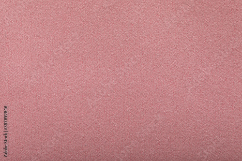Fine grain pink texture background. Velvet scarlet matte background of suede fabric