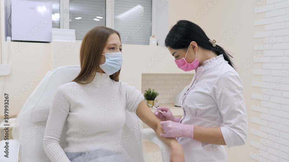Doctor makes the patient an injection. The doctor in clinic takes a blood sample to the test with the patient's arm Doctor makes the patient an injection. The doctor in clinic takes a blood sample to the test with the patient's arm