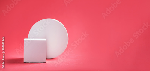 Abstract empty geometric shape podium for product on pastel red background. Copy space. White cube on pink backdrop. Pedestal template for advertising. Trendy minimal concept. Mock up © jchizhe