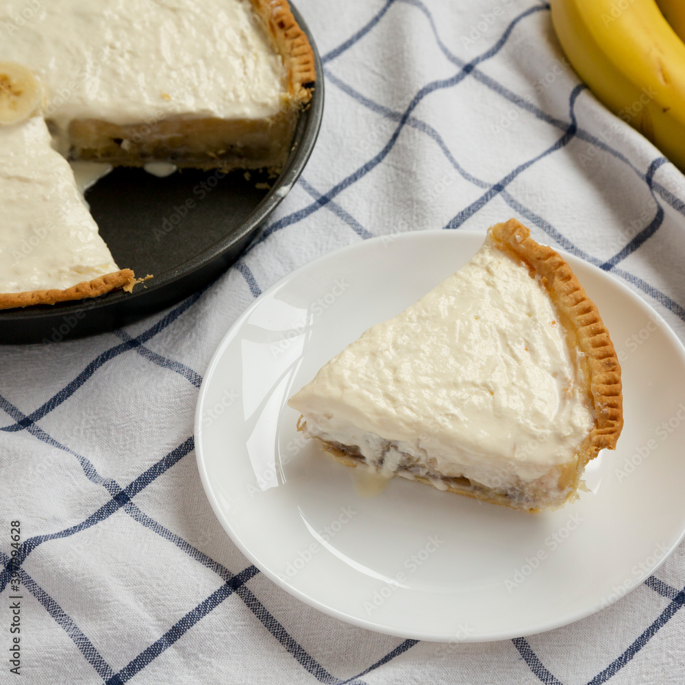 Homemade Tasty Banana Cream Pie on cloth, side view.