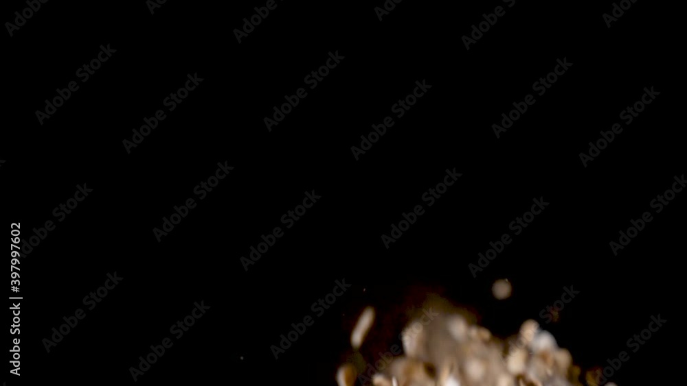 Nutritious Ingredient of Oat Flakes Falling into Black Background Nutritious Ingredient of Oat Flakes Falling into Black Background