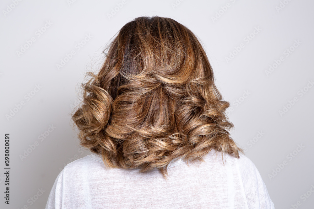 Back view portrait of beautiful dark blonde woman against white background Back view portrait of beautiful dark blonde woman against white background