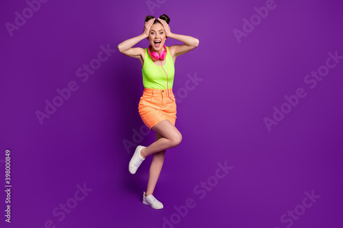 Full length body size view of pretty amazed cheerful girl listening disco having fun dancing isolated on bright violet color background