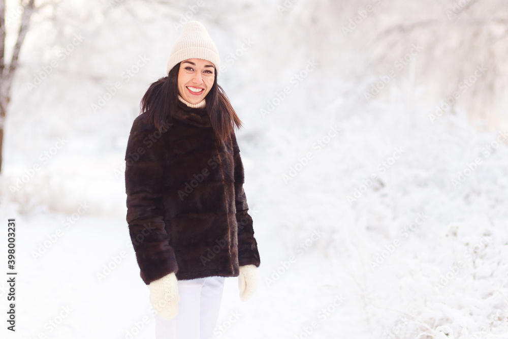 young smiling woman in brown mink fur coat and white winter mittens young smiling woman in brown mink fur coat and white winter mittens