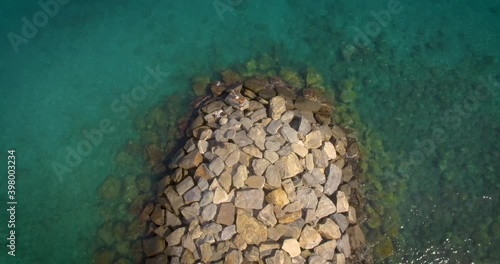 Birds eye view of a rock breakwater on the green and calm Caribbean Sea photo