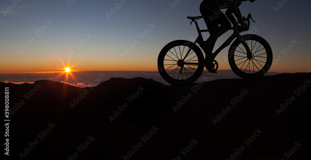 Fototapeta premium The silhouette of the cyclist on bike at sunset.A man ride on bike on the mountains. Sport and active life concept sunset time. A man riding a bicycle in a nature.