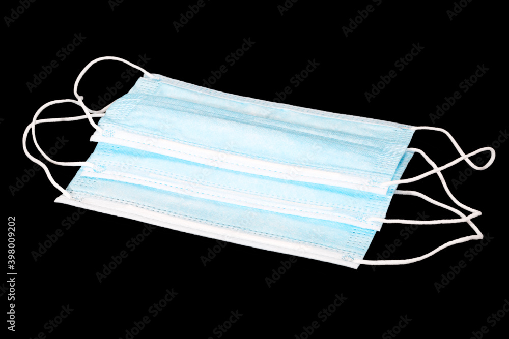 Medical protective face mask used on the face during the covid 19 pandemic to protect against coronavirus. Several masks isolated on a black background Medical protective face mask used on the face during the covid 19 pandemic to protect against coronavirus. Several masks isolated on a black background