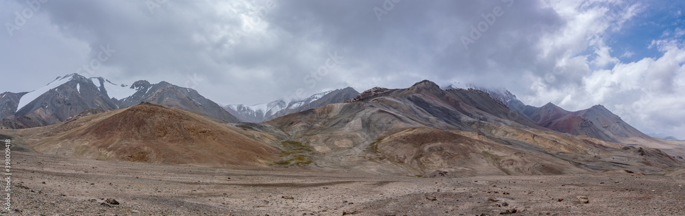 Landscape panorama with pastel colors of mountains along high-altitude Pamir Highway at Ak Baital pass, Murghab district, Gorno-Badakshan, Tajikistan