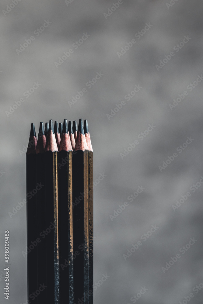 Simple graphite pencils on grey background. Black pencils 