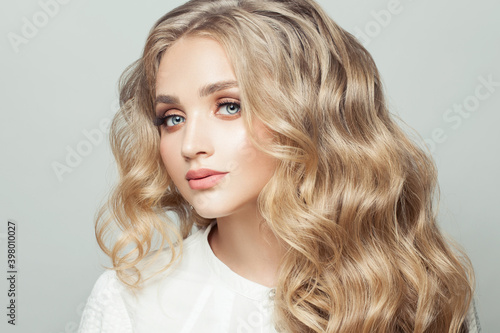 Perfect young woman with long curly hairstyle on white background