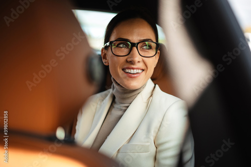 Positive pleased business woman sitting in a car