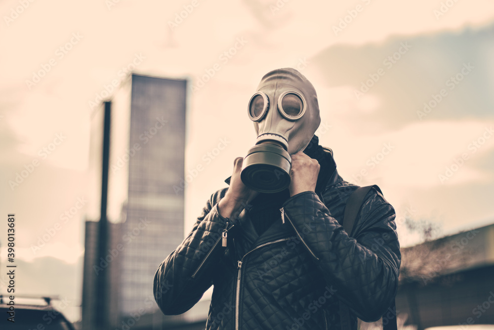 young man wearing a gas mask on a city street young man wearing a gas mask on a city street