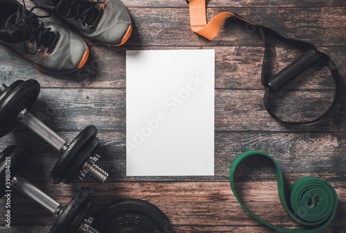 Paper on wooden floor with gym equipment.