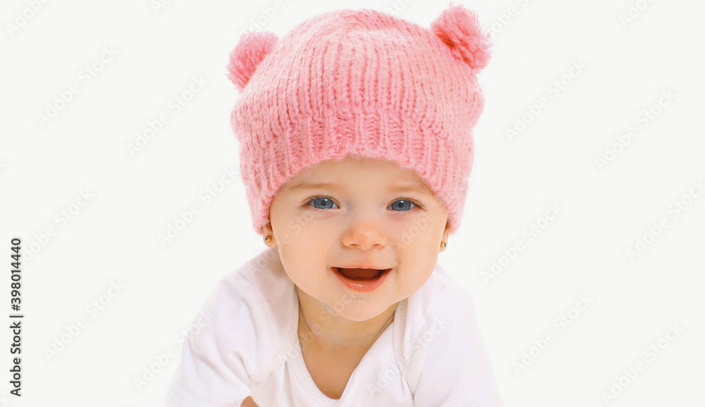 Portrait close up of sweet baby wearing a knitted pink hat over a white background Portrait close up of sweet baby wearing a knitted pink hat over a white background