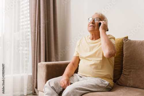 Tableau sur toile Senior man wearing eyeglasses is using smartphone
