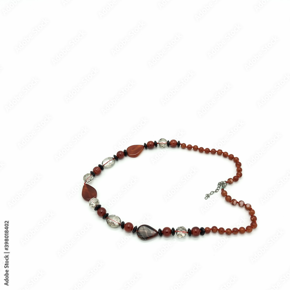 Women's bijouterie. Necklace made of terracotta, black and transparent beads of various shapes. Metal clasp. Isolated on white background. Women's bijouterie. Necklace made of terracotta, black and transparent beads of various shapes. Metal clasp. Isolated on white background.
