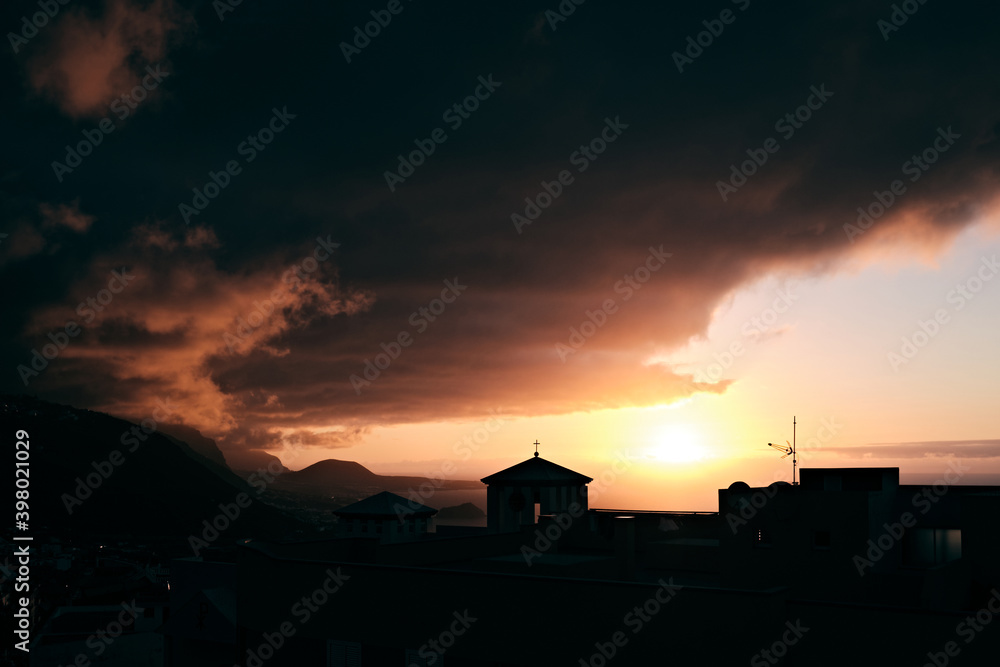 Tramonto tra le nubi dietro una chiesa