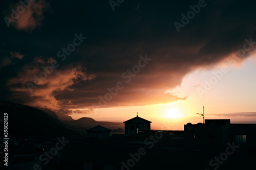 Tramonto tra le nubi dietro una chiesa