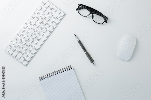 Glasses keyboard mouse notepad and pen on white background