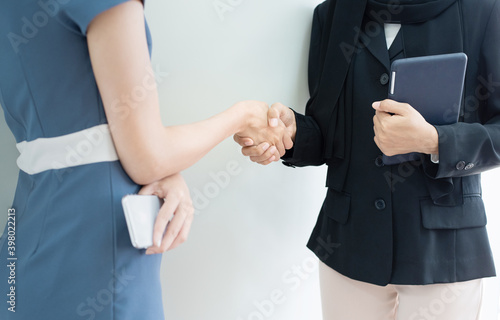 closed up hand cheacking of two woman one in muslim hijap hand hold tablet one dress in modern siut hand hold smart phone,success business concept. photo