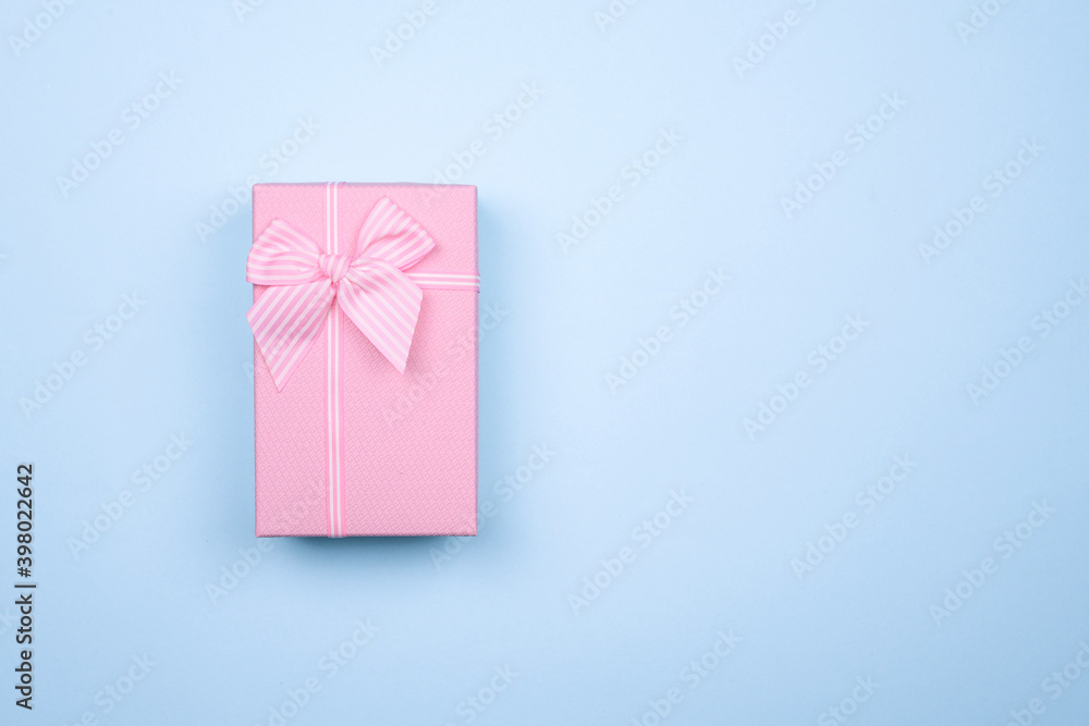 Gift rectangular pink box with bow on a pure blue background Gift rectangular pink box with bow on a pure blue background