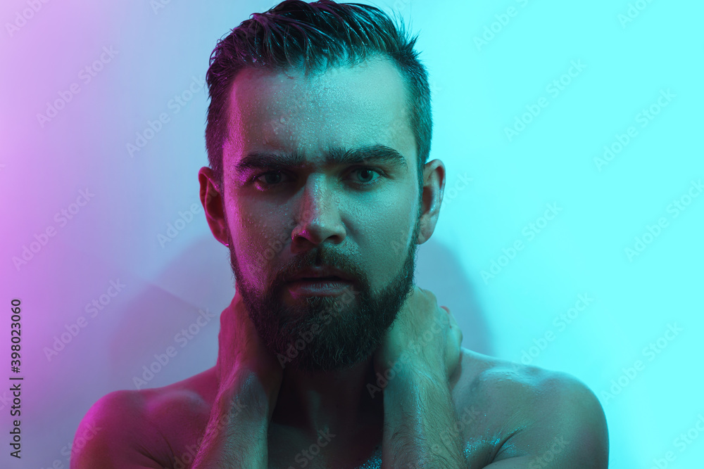 Handsome young man with wet skin in neon light Handsome young man with wet skin in neon light