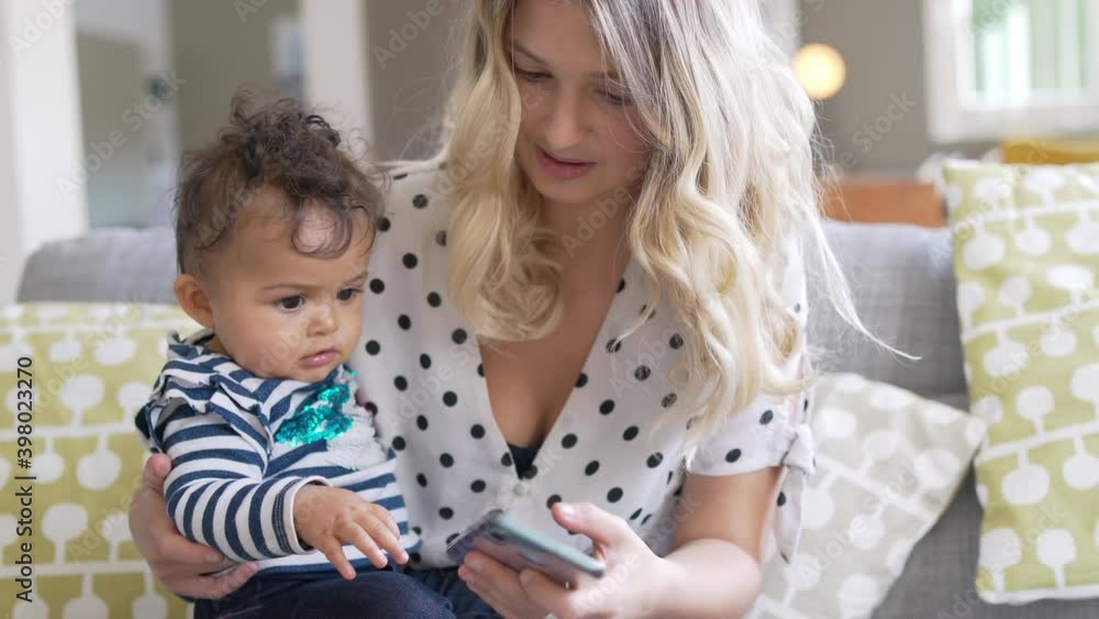 Young mom with baby girl playing with smartphone Young mom with baby girl playing with smartphone