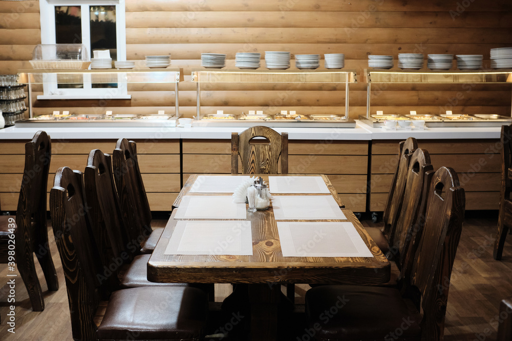 massive wooden table in the dining room. The concept of a vacation in a country club. massive wooden table in the dining room. The concept of a vacation in a country club.
