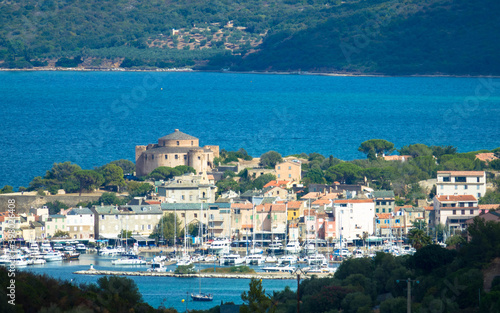 Panorama of beautiful Saint Florent fishing village, harbour and the citadel in the background. Corsica, France