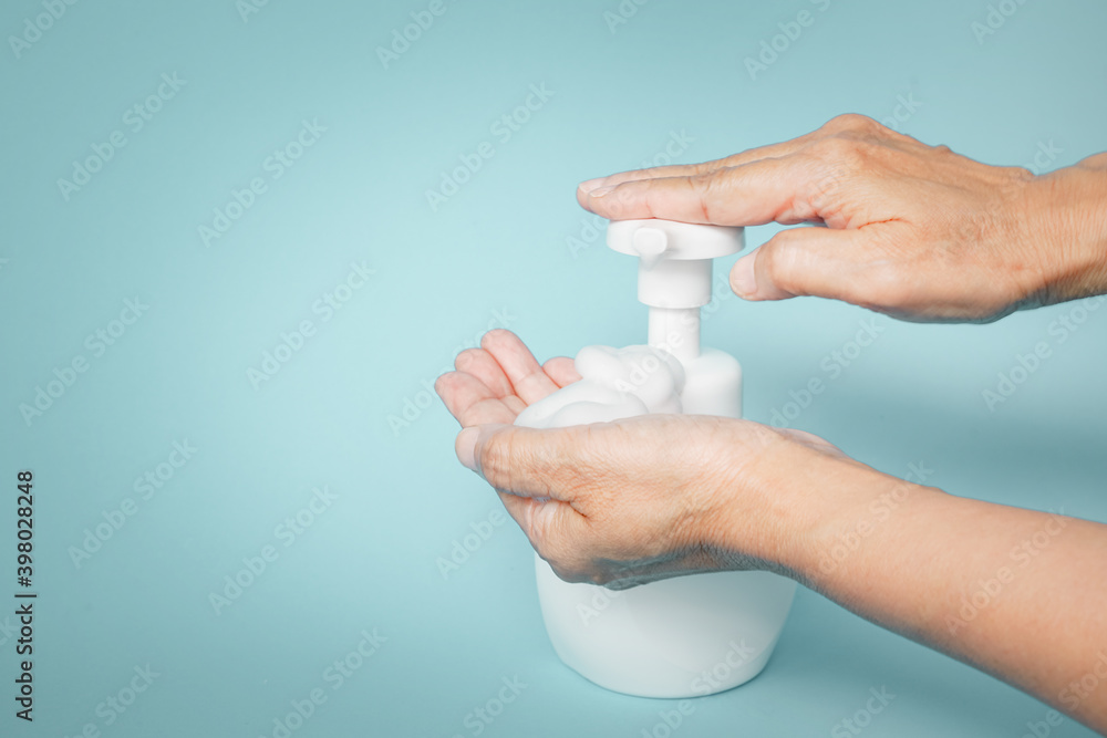 soap foam in old people's hand with the other press dispenser pump of white bottle for cleaning hand , new normal lifestyle concept soap foam in old people's hand with the other press dispenser pump of white bottle for cleaning hand , new normal lifestyle concept