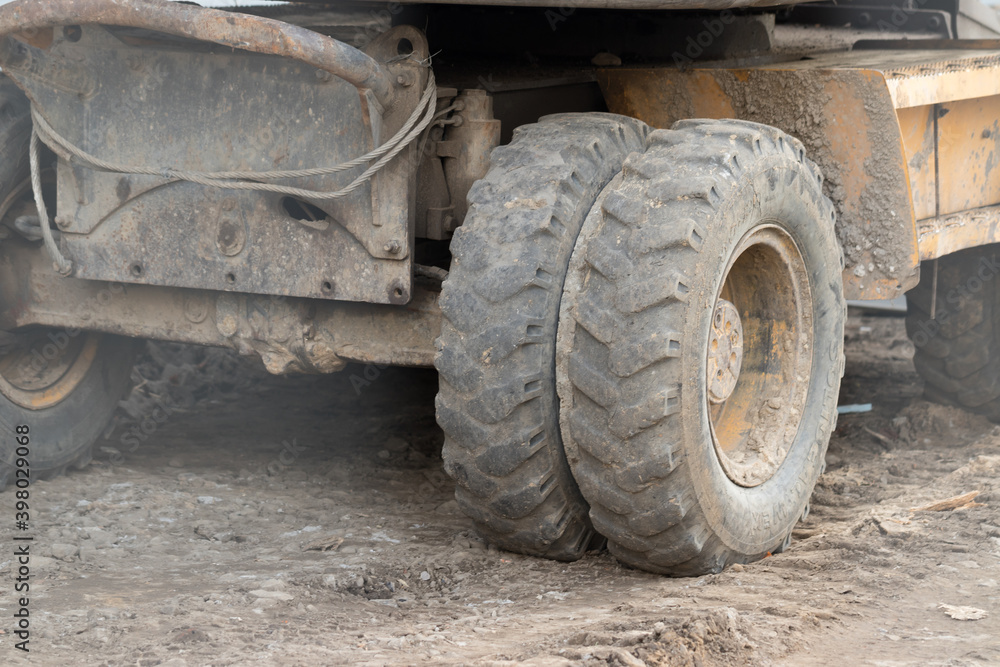 Muddy excavator wheel at the construction site. Muddy excavator wheel at the construction site.