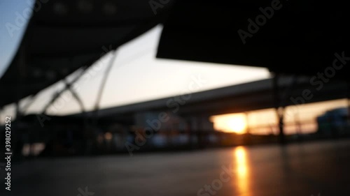 Blurred people walking on walkway with sunset in twilight.